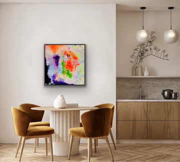 Einrichtungsbeispiel in einem modernen Esszimmer: Das farbstarke, abstrakte Gemälde hängt in einem schwarzen Rahmen an einer hellen Wand über einem runden Esstisch mit senfgelben Samtstühlen. Rechts daneben ist eine minimalistische Holzküche zu sehen.