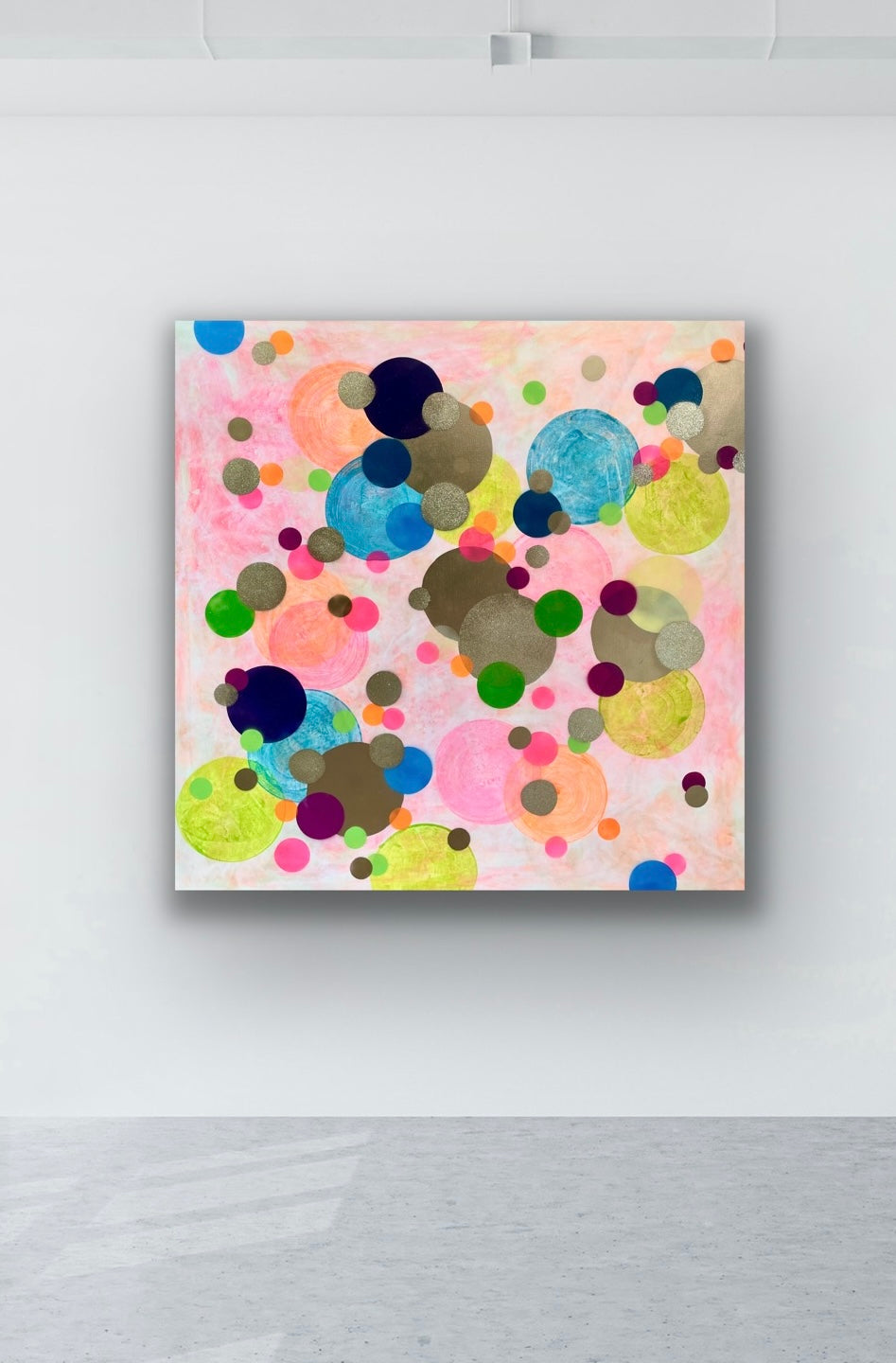 Einrichtungsbeispiel in einer Galerie: Das riesige, bunte Gemälde 'Confetti' hängt rahmenlos an einer großen, weißen Wand über einem grauen Betonboden. Es wirkt wie ein fröhlicher Farbtupfer im minimalistischen Raum.