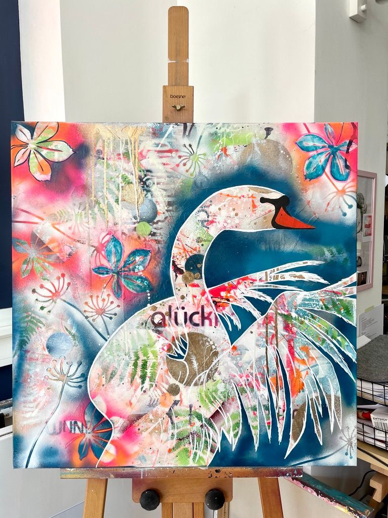Authentischer Einblick ins Atelier: Das bunte, 100x100 cm große Schwanen-Gemälde 'Swan' steht auf einer hölzernen Künstler-Staffelei in der Werkstatt der Künstlerin Diana Gumz.