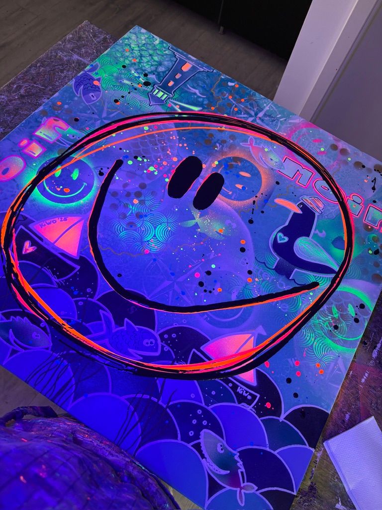 Nahaufnahme des Pop-Art Gemäldes 'Küsten Smile' unter Schwarzlicht (UV-Licht). Der Smiley, die Segelboote, Fische und 'Moin'-Texte leuchten in spektakulären, fluoreszierenden Neon-Farben.